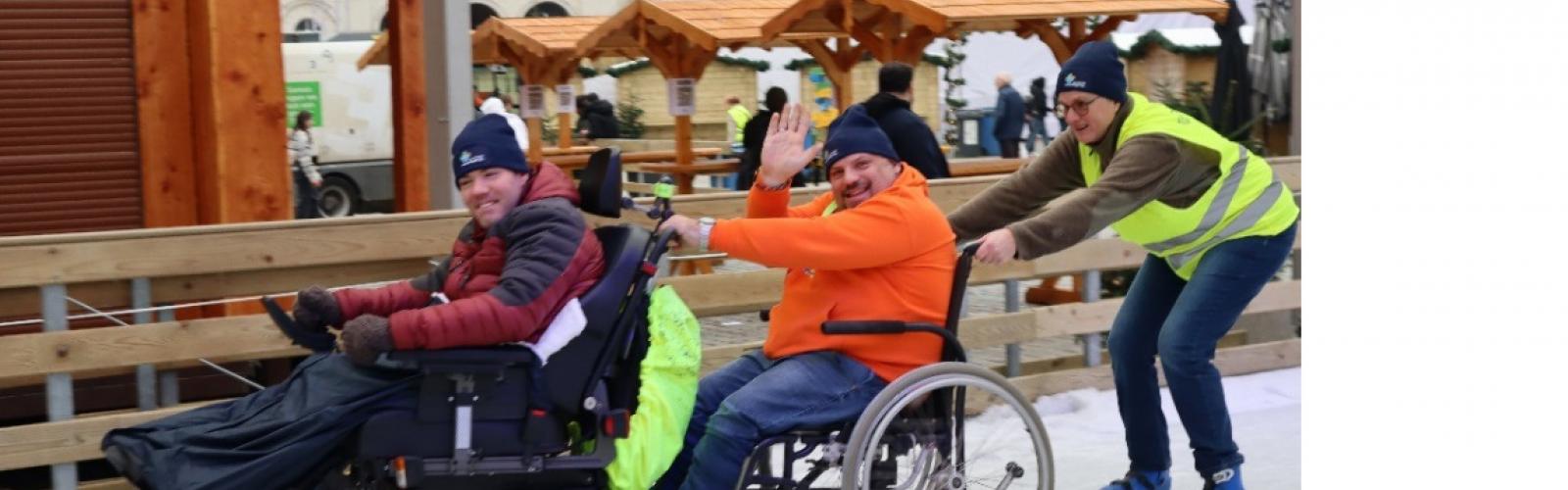 3 mensen achter elkaar op de schaatsbaan, waarbij de eerste 2 in een rolstoel.